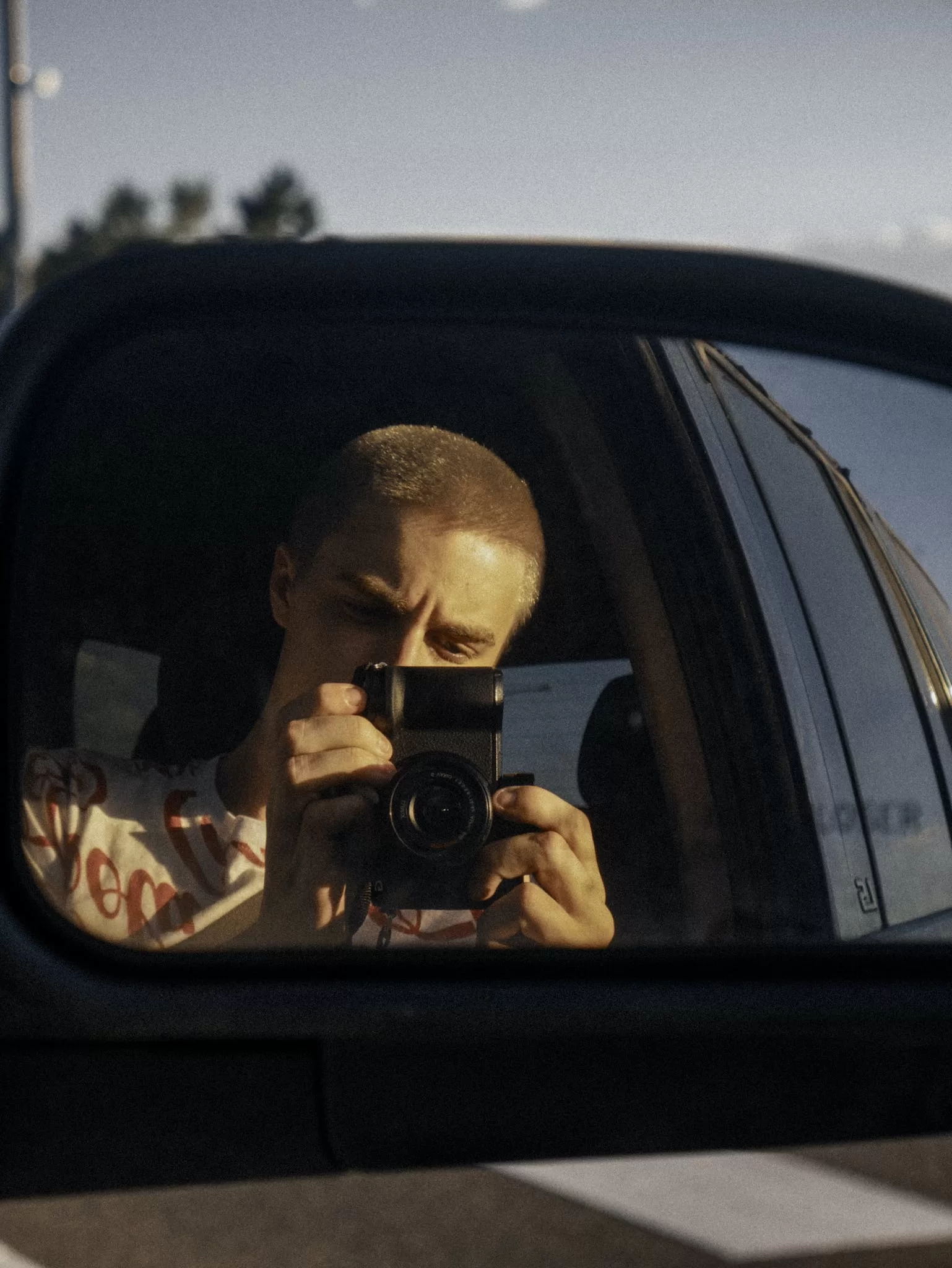 A Man Takes A Photo Reflection Of A Vehicle Side Mirror